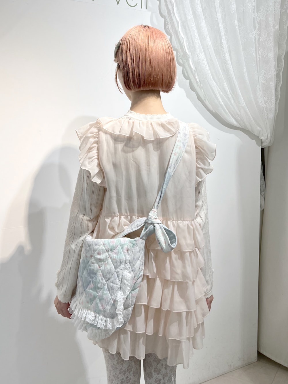 ホワイト系のショルダーバッグ、ピンク系のシャツ/ブラウス、ホワイト系のニット/セーターを着用したレディースの秋コーディネートの6枚目の写真