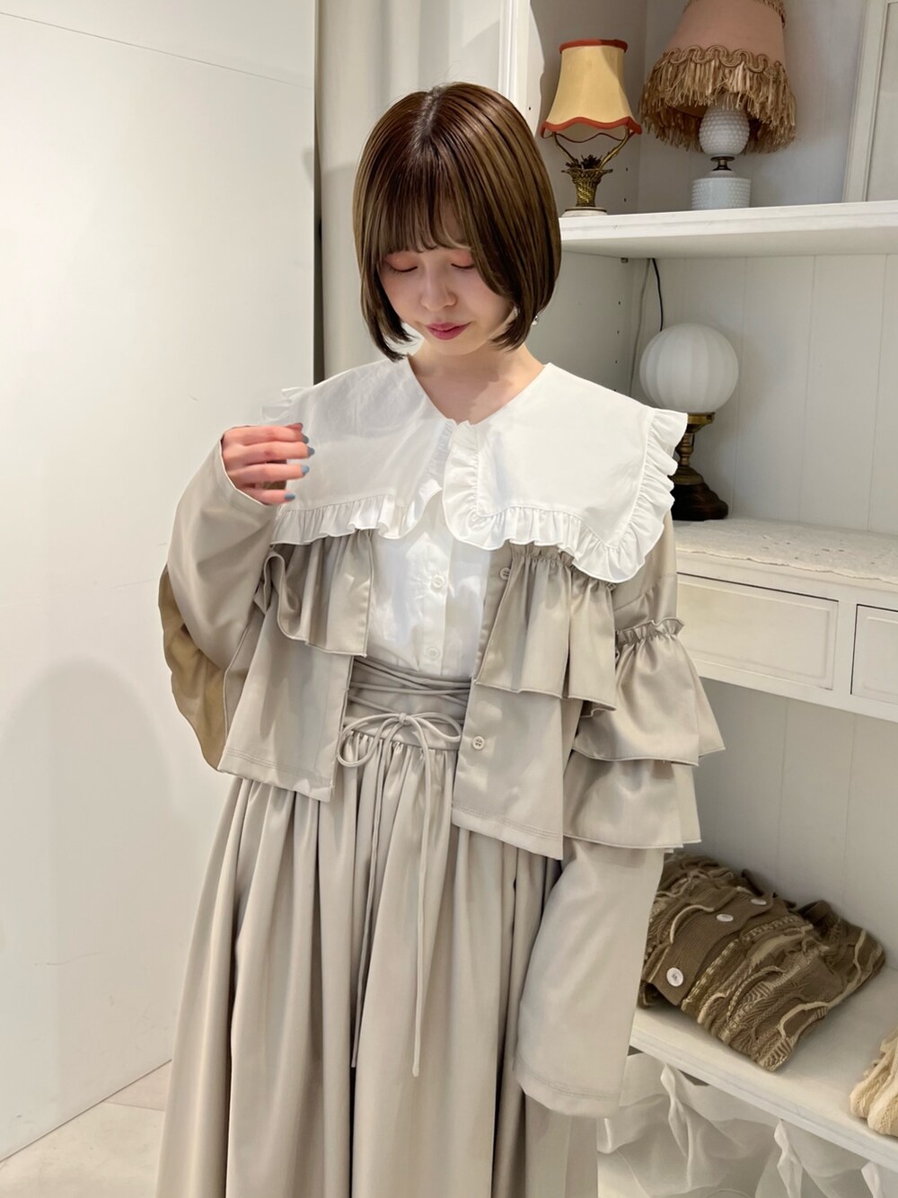 ホワイト系のシャツ/ブラウス、ベージュ系のスカート、ベージュ系のブーツを着用したレディースの冬コーディネートの7枚目の写真