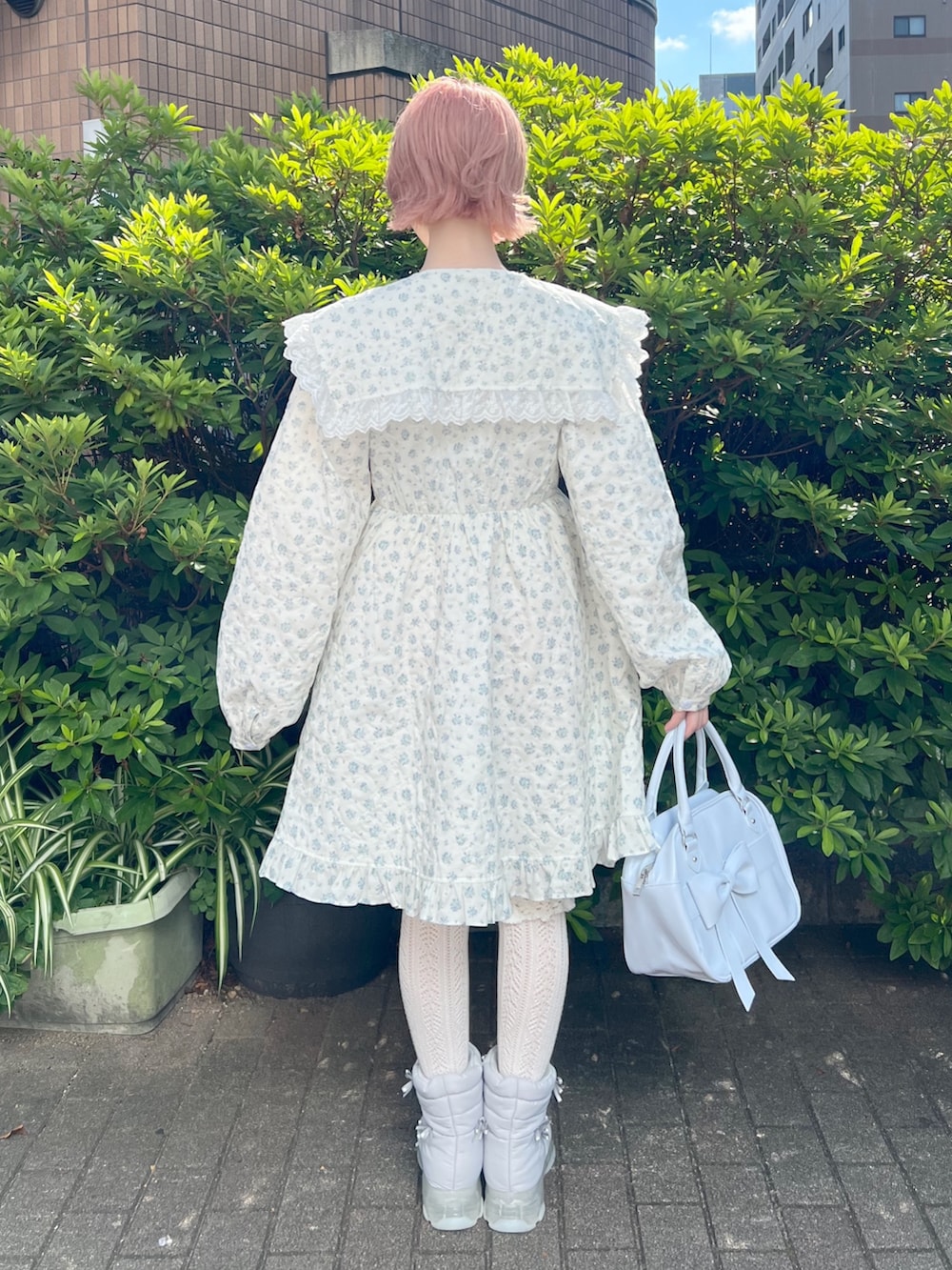 ホワイト系のワンピース、ブルー系のハンドバッグ、ブルー系のブーツを着用したレディースの夏コーディネートの3枚目の写真