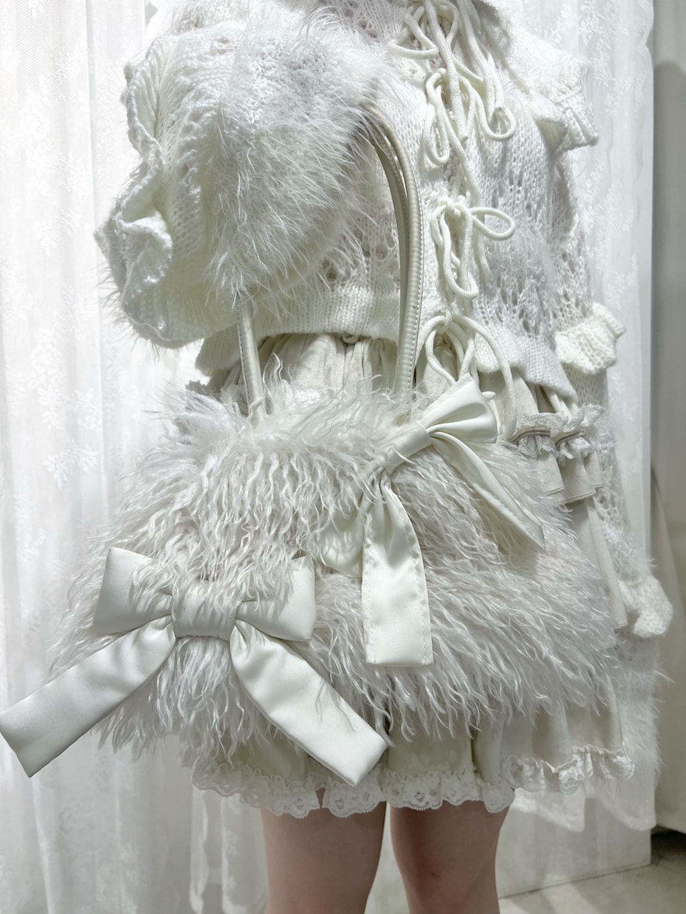 ホワイト系のボストンバッグ、ブラウン系のブーツ、ホワイト系のスカートを着用したレディースの夏コーディネートの9枚目の写真