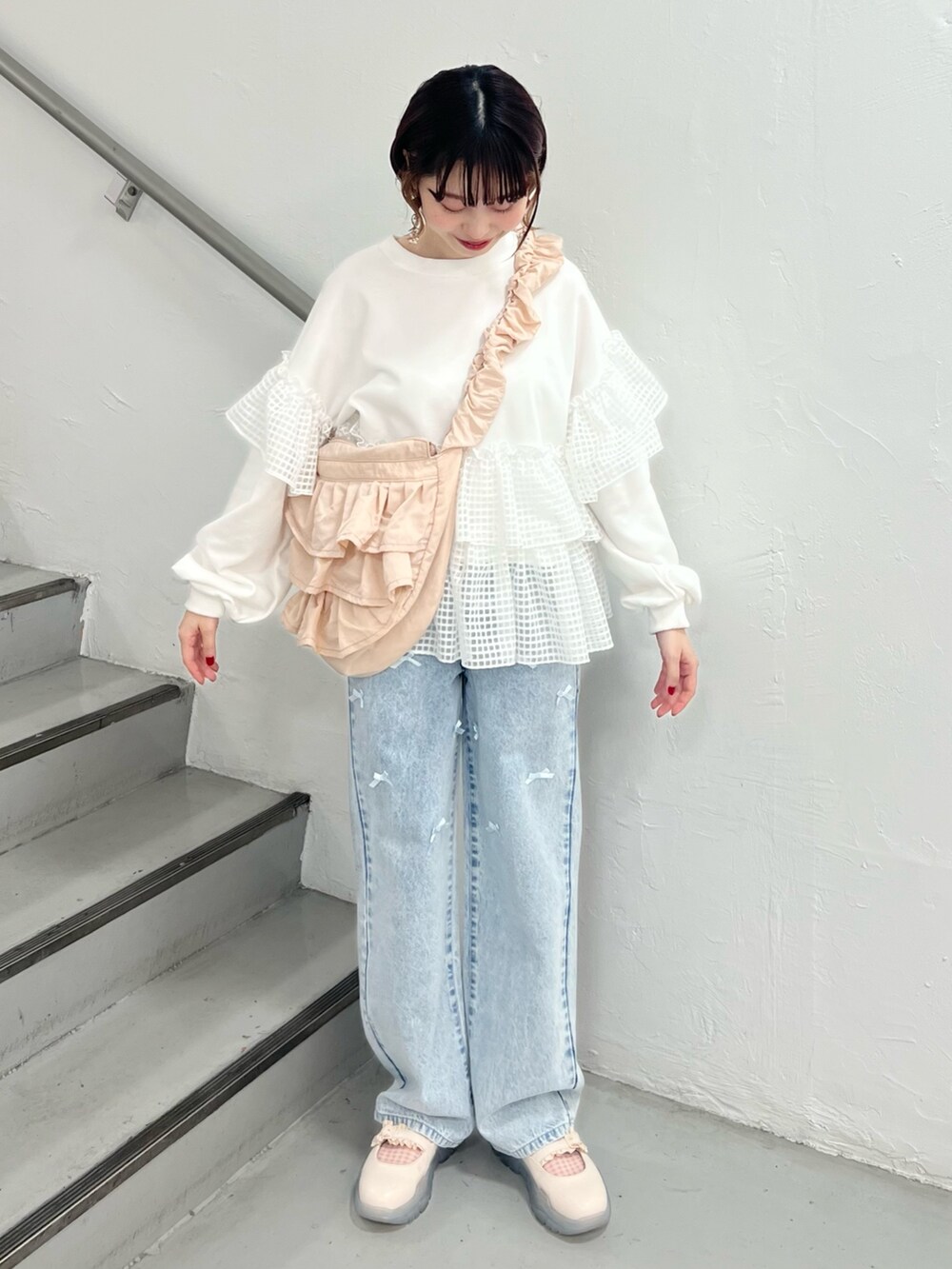 ホワイト系のスウェット、ブルー系のデニムパンツ、ホワイト系のスニーカーを着用したレディースの春コーディネートの5枚目の写真