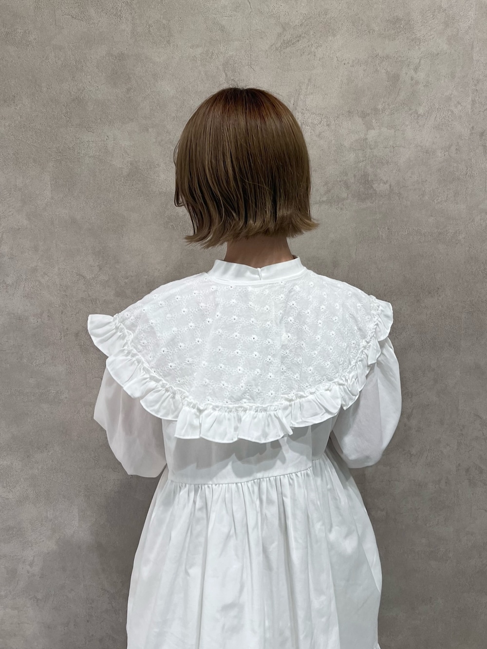 ブルー系のその他アウター、ホワイト系のワンピース、ホワイト系のローファーを着用したレディースの冬コーディネートの8枚目の写真