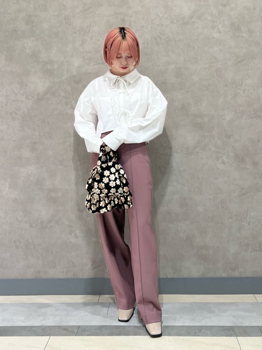 ホワイト系のシャツ/ブラウス、ピンク系のスラックス、ベージュ系のブーツを着用したレディースの秋コーディネートの2枚目の写真