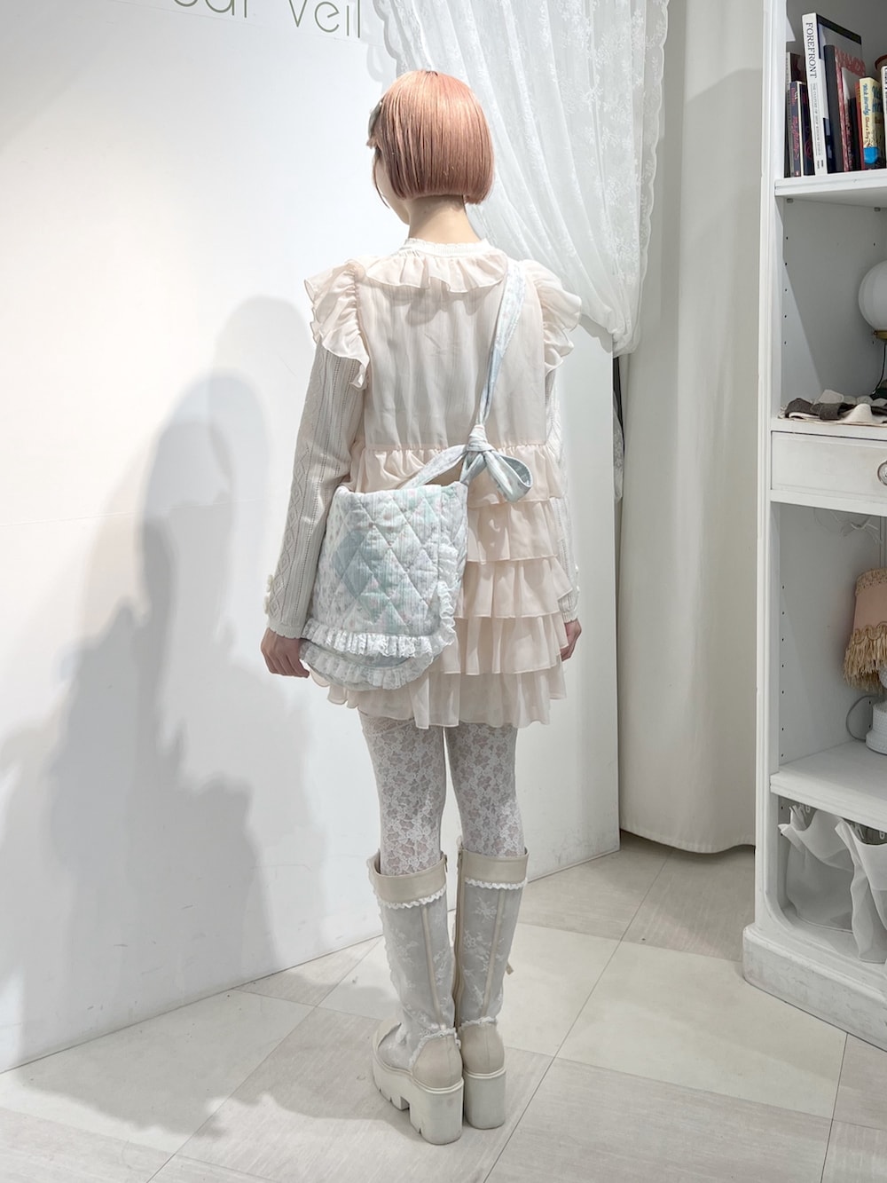 ホワイト系のショルダーバッグ、ピンク系のシャツ/ブラウス、ホワイト系のニット/セーターを着用したレディースの秋コーディネートの3枚目の写真
