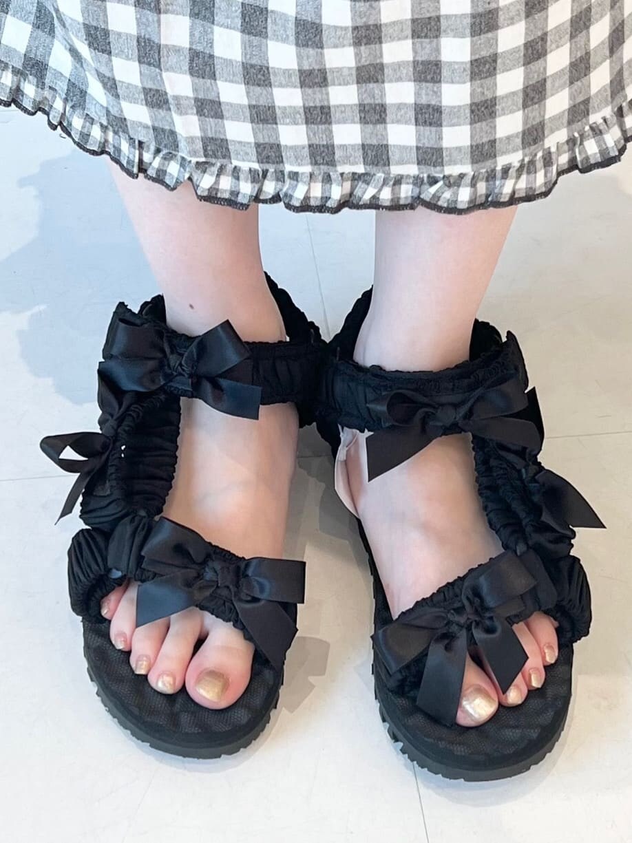 ホワイト系のショルダーバッグ、ブラック系のスカート、ブラック系のサンダルを着用したレディースの夏コーディネートの6枚目の写真