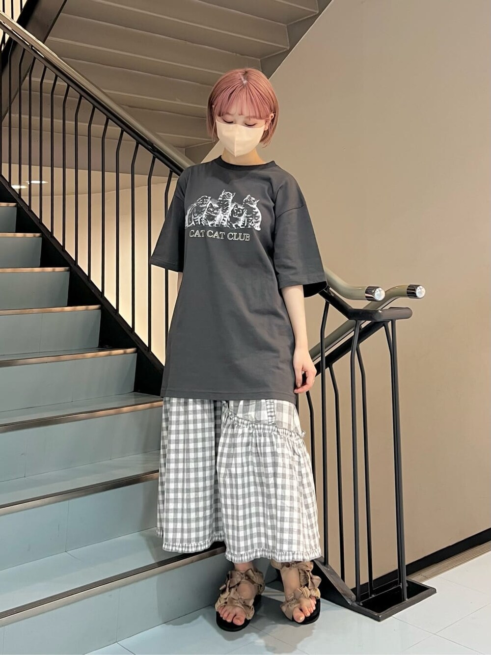 グレー系のスカート、ベージュ系のサンダル、グレー系のTシャツ/カットソーを着用したレディースの夏コーディネートの3枚目の写真