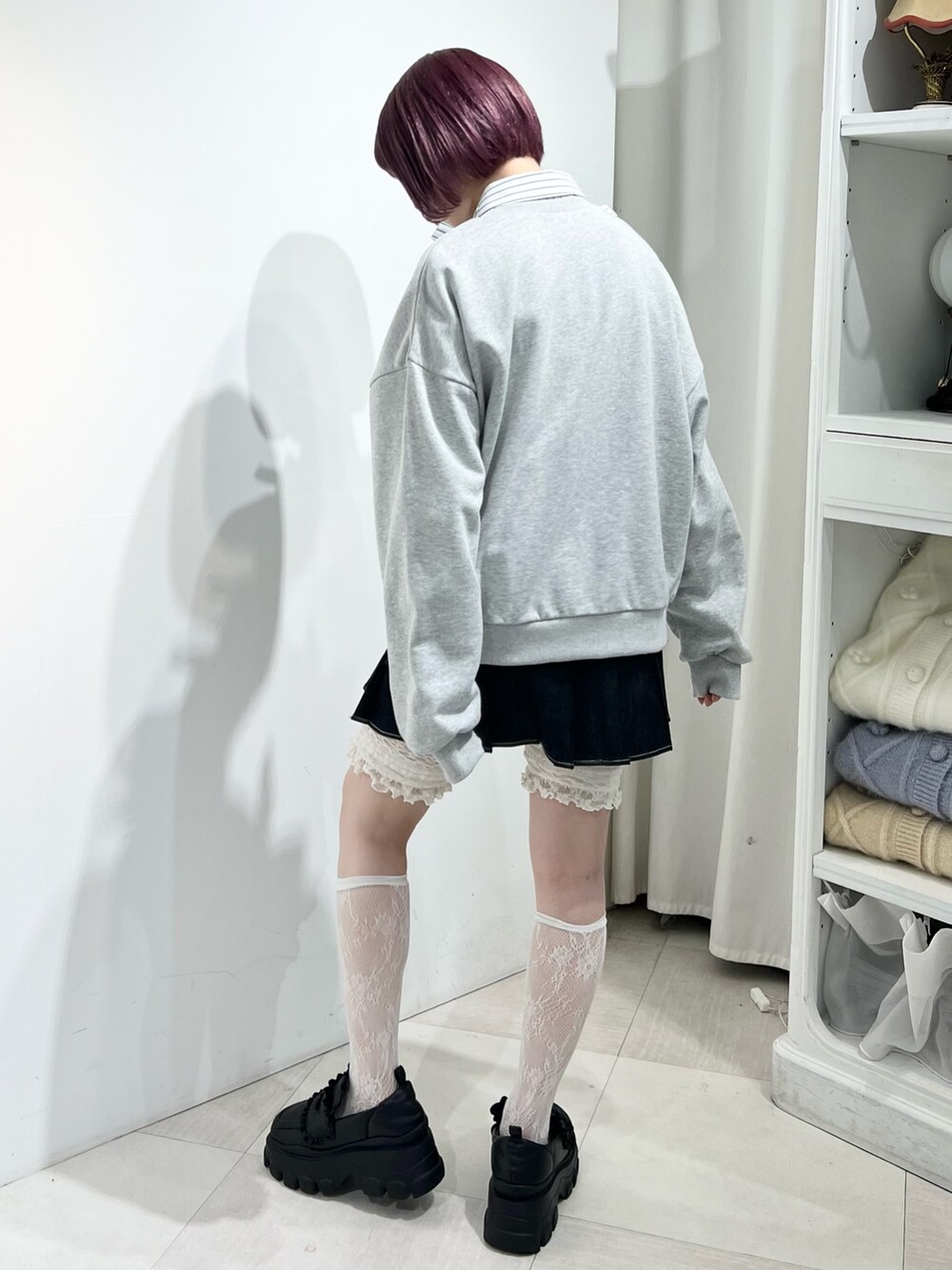 グレー系のスウェット、ブラック系のスカート、ブラック系のローファーを着用したレディースの秋コーディネートの5枚目の写真