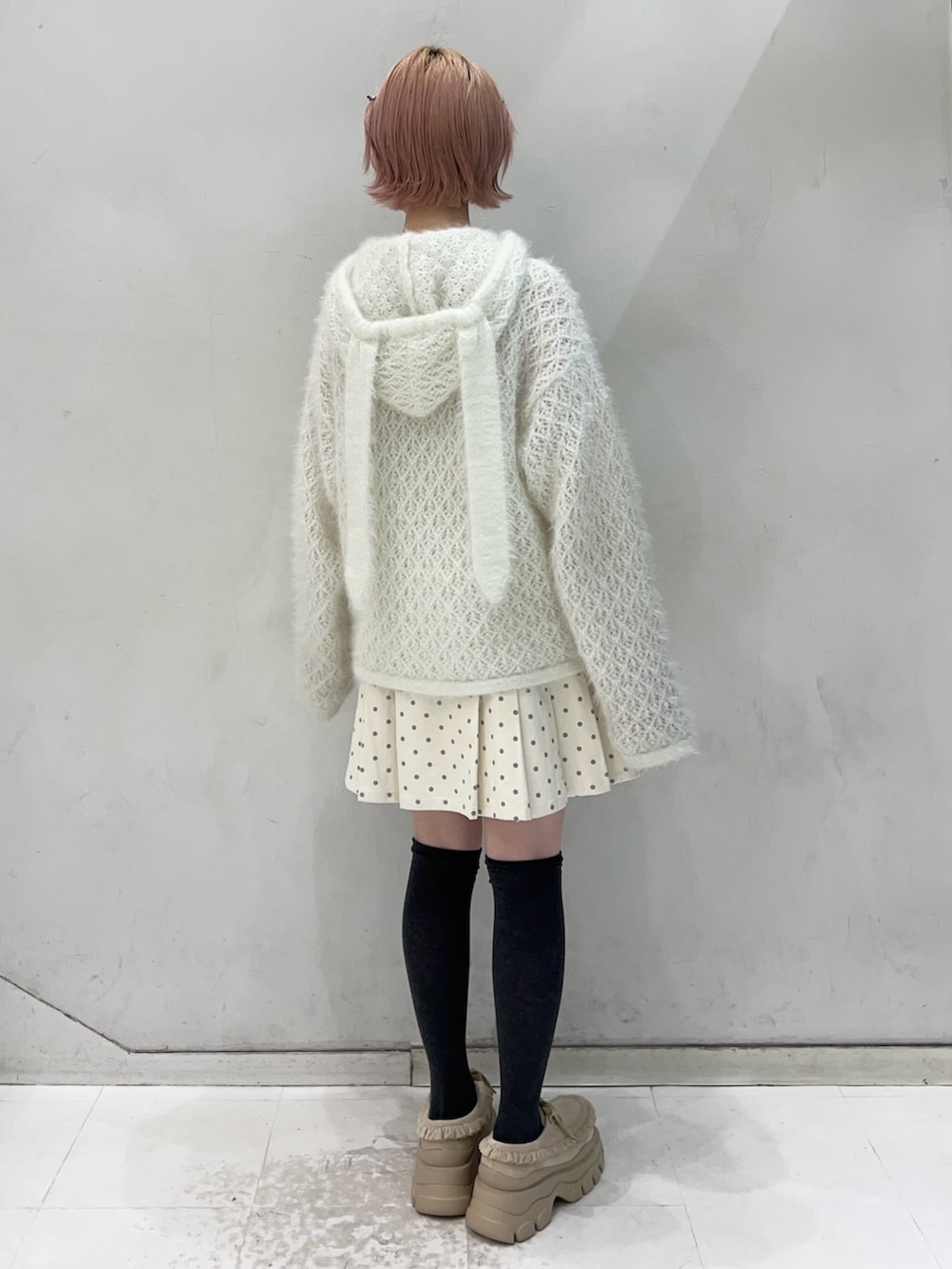 ホワイト系のニット/セーター、ホワイト系のスカート、ベージュ系のローファーを着用したレディースの冬コーディネートの2枚目の写真