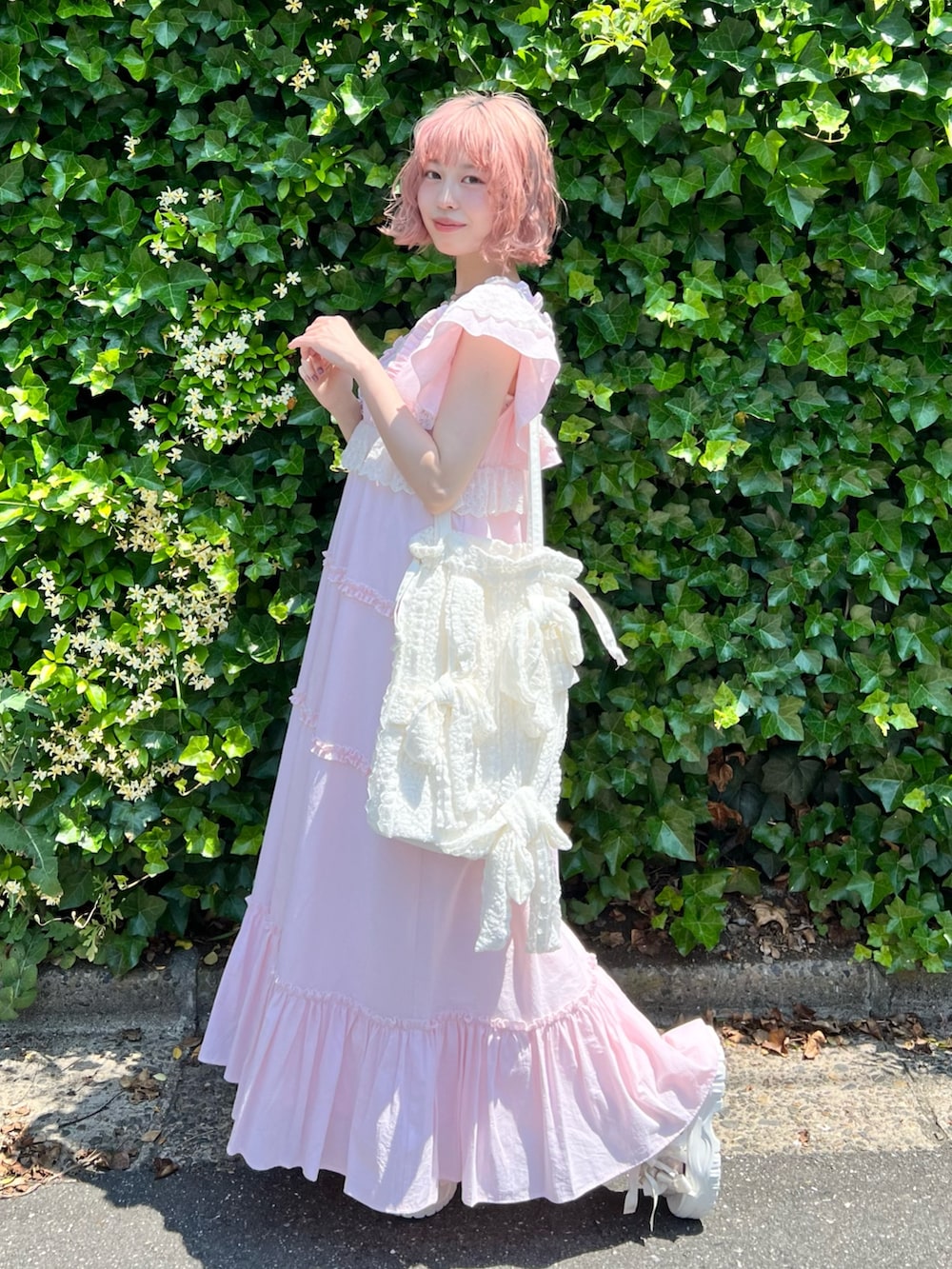 ピンク系のワンピース、ピンク系のキャミソール、ホワイト系のトートバッグを着用したレディースの夏コーディネートの3枚目の写真