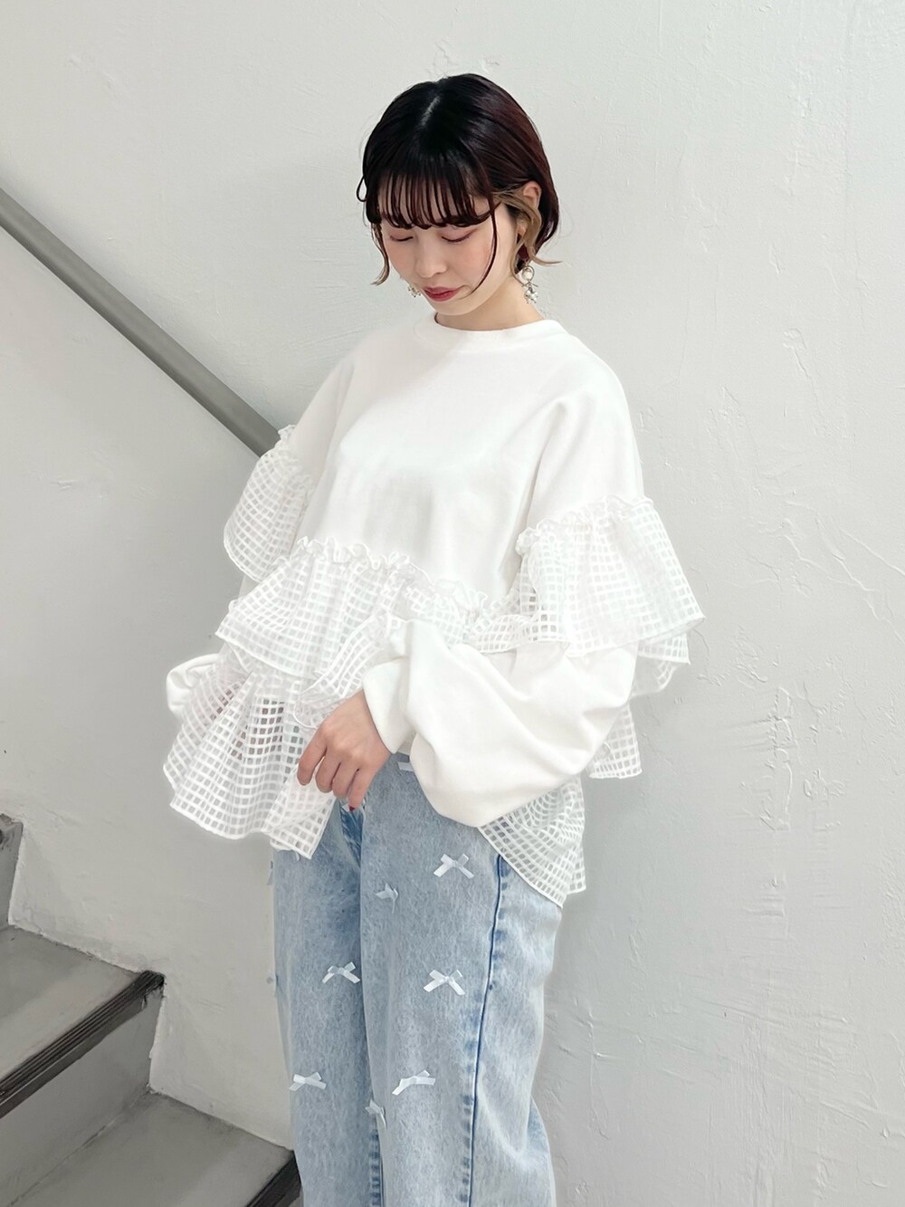 ホワイト系のスウェット、ブルー系のデニムパンツ、ホワイト系のスニーカーを着用したレディースの春コーディネートの7枚目の写真