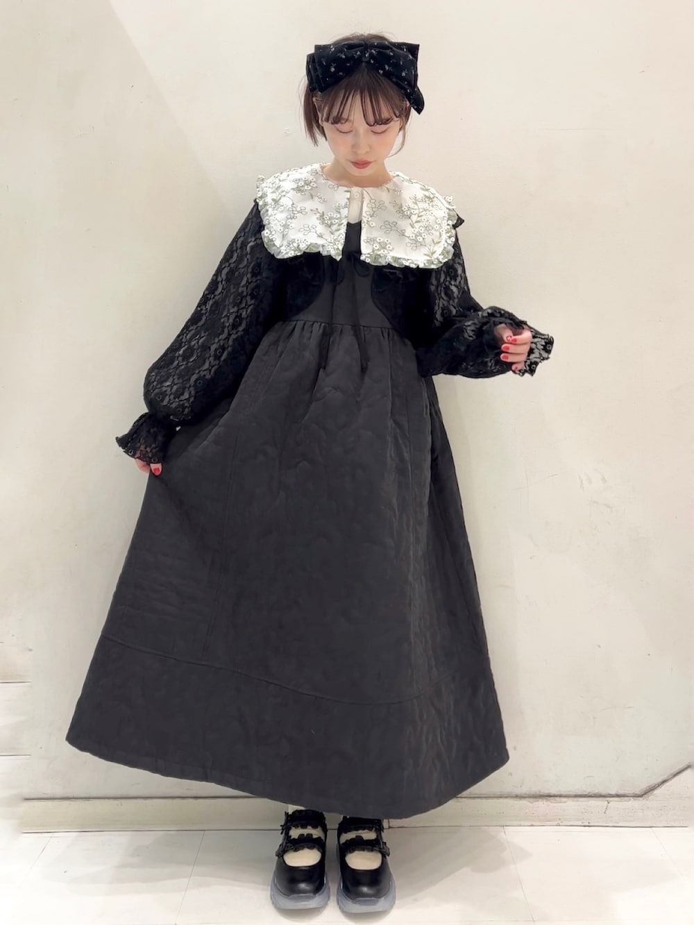 ブラック系のワンピース、ブラック系のカーディガン/ボレロ、ブラック系のスニーカーを着用したレディースの冬コーディネートの6枚目の写真