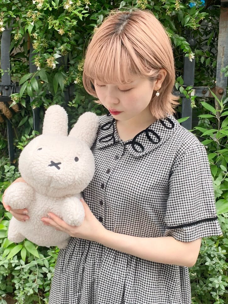 ブラック系のスニーカー、ブラック系のワンピース、ホワイト系のハンドバッグを着用したレディースの夏コーディネートの3枚目の写真