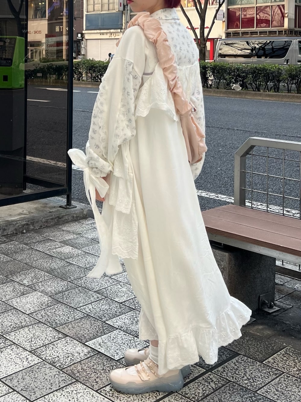 ピンク系のショルダーバッグ、ホワイト系のスニーカー、ホワイト系のワンピースを着用したレディースの春コーディネートの4枚目の写真