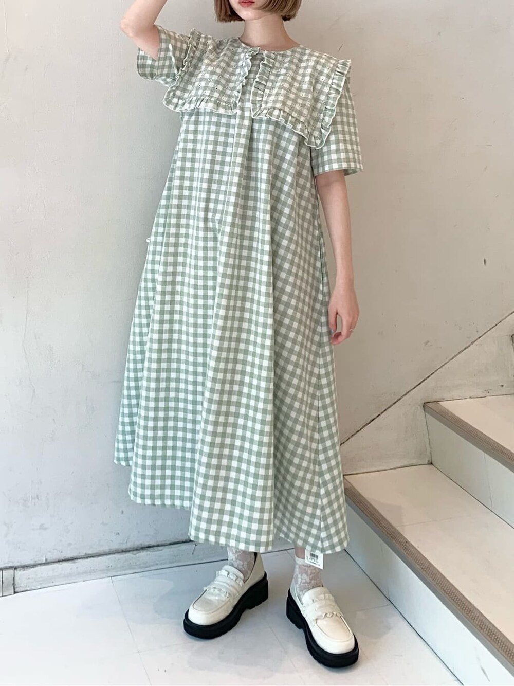 ホワイト系のローファー、グリーン系のワンピース、ホワイト系のトートバッグを着用したレディースの春コーディネートの2枚目の写真