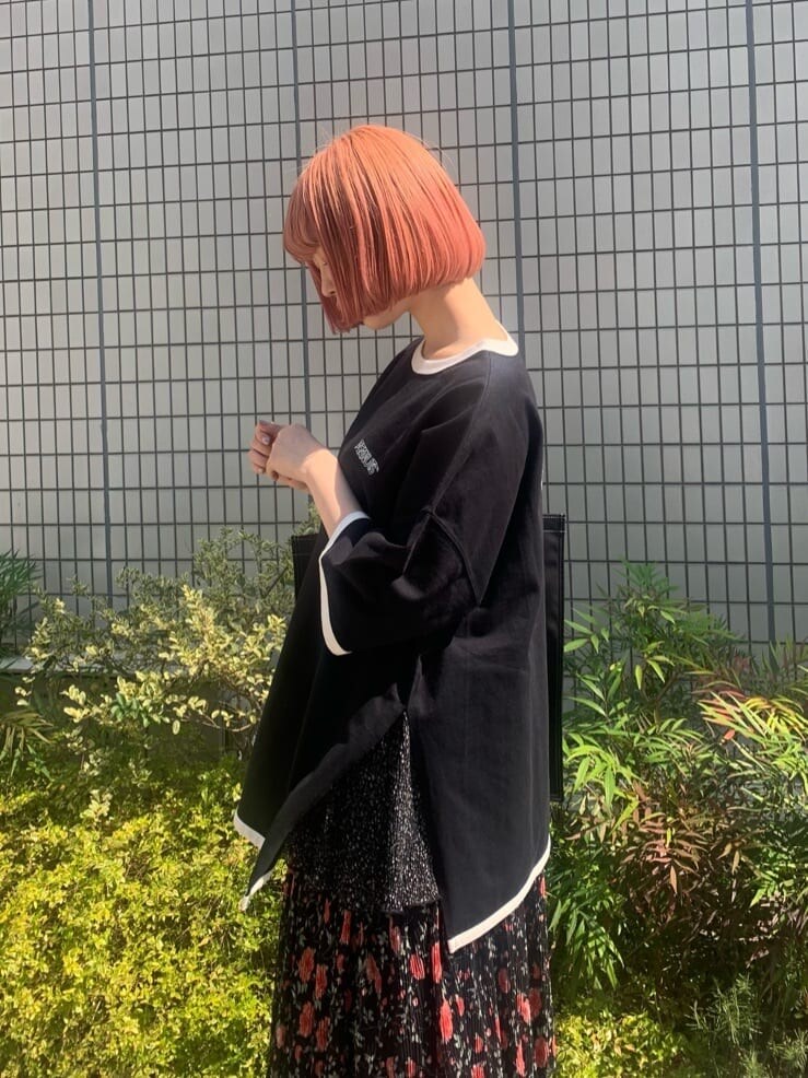 ブラック系のパンプス、ブラック系のスカート、ブラック系のトートバッグを着用したレディースの春コーディネートの5枚目の写真