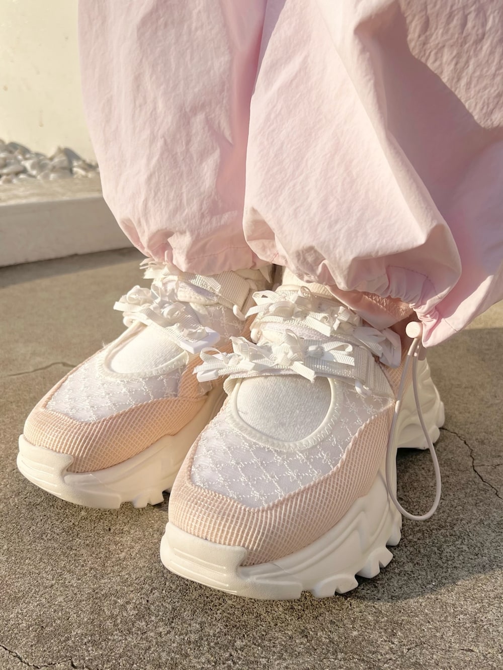 ピンク系のジャージ、ピンク系のカーゴパンツ、ピンク系のスニーカーを着用したレディースの冬コーディネートの10枚目の写真