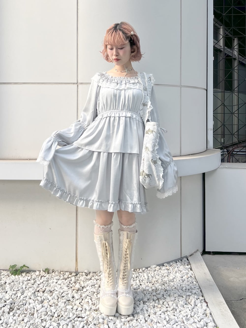 ブルー系のワンピース、ブルー系のトートバッグ、ホワイト系のブーツを着用したレディースの夏コーディネートの3枚目の写真