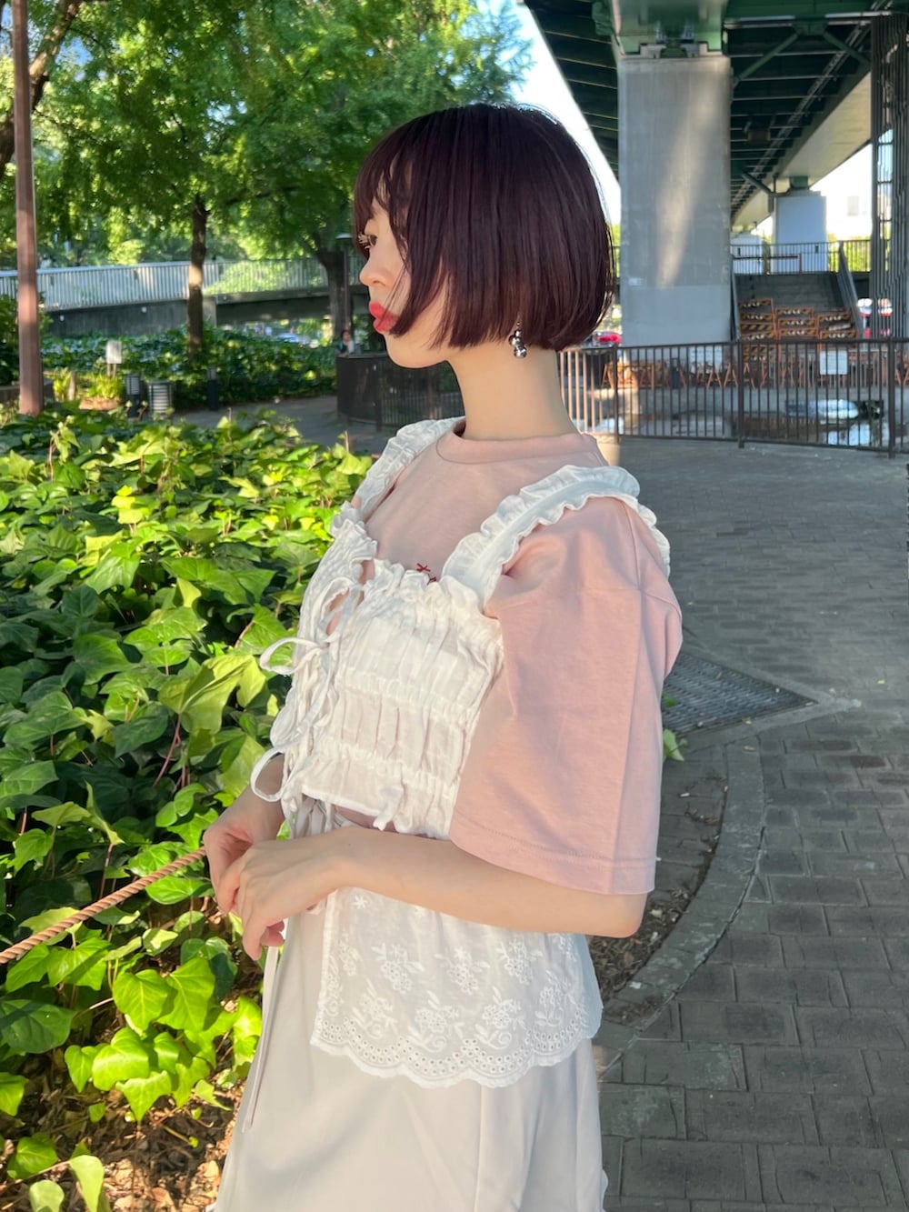 ピンク系のサンダル、ピンク系のボディバッグ/ウエストポーチ、ホワイト系のスカートを着用したレディースの夏コーディネートの9枚目の写真