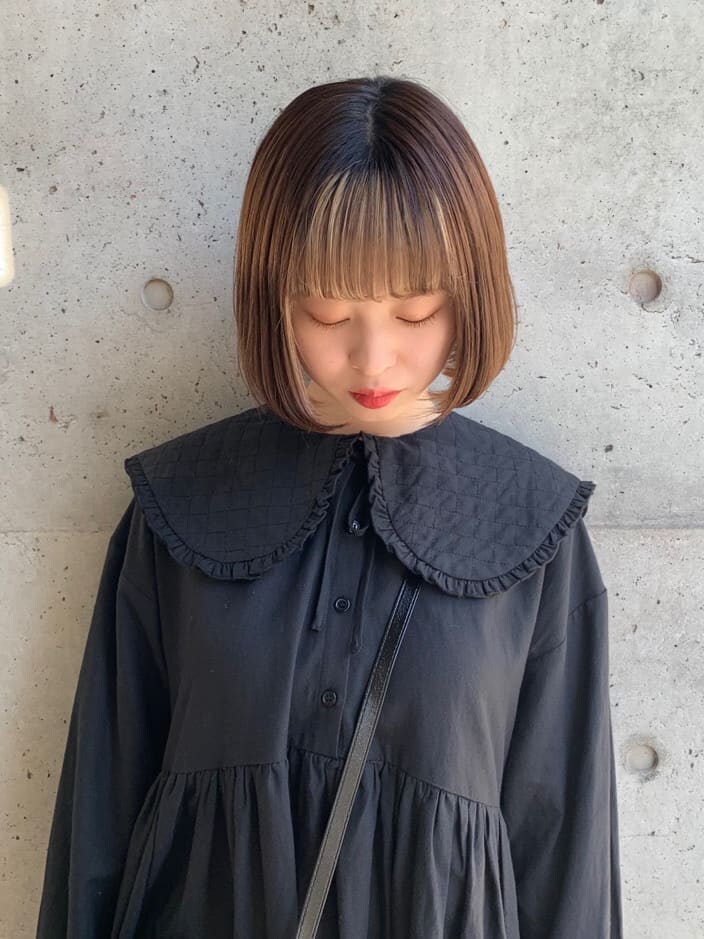 ブラック系のパンプス、ブラック系のワンピース、ブラック系のショルダーバッグを着用したレディースの冬コーディネートの5枚目の写真