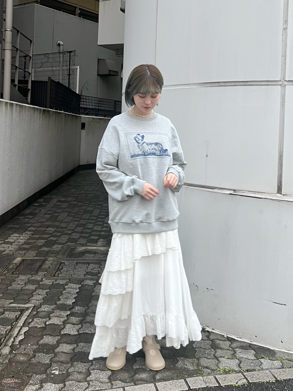 ベージュ系のブーツ、ベージュ系のトレンチコート、グレー系のスウェットを着用したレディースの冬コーディネートの7枚目の写真