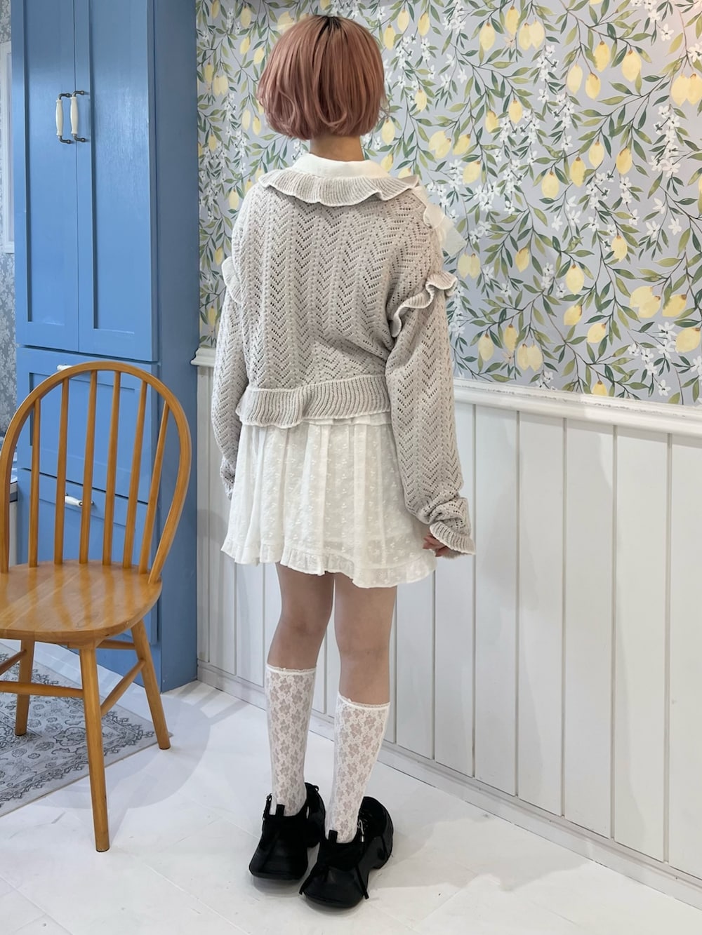 グレー系のカーディガン/ボレロ、ホワイト系のシャツ/ブラウス、ホワイト系のスカートを着用したレディースの冬コーディネートの5枚目の写真