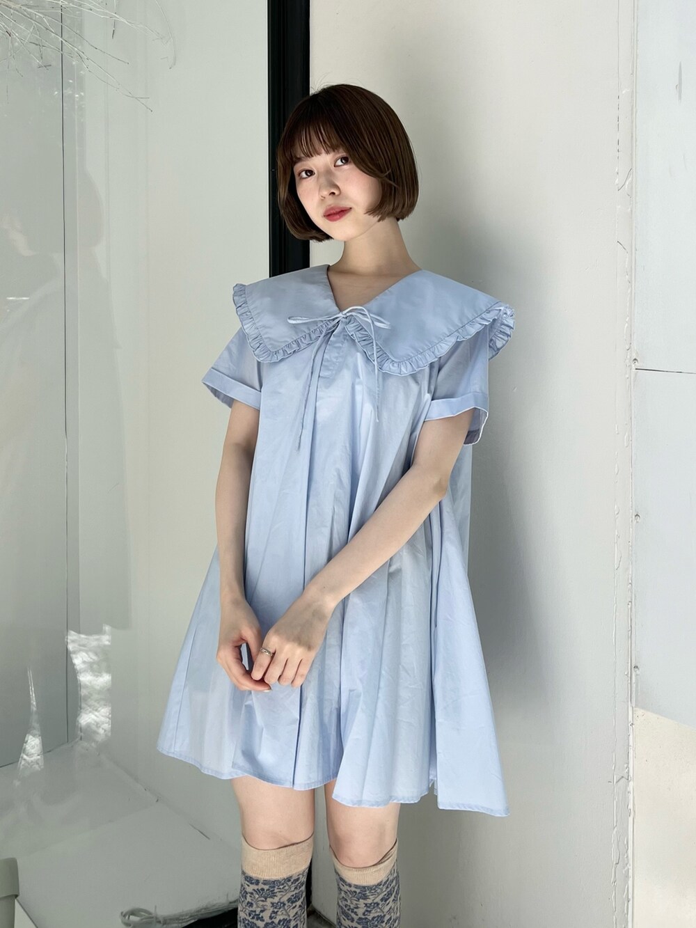 ブルー系のワンピース、ホワイト系のサンダル、ホワイト系のショルダーバッグを着用したレディースの春コーディネートの5枚目の写真