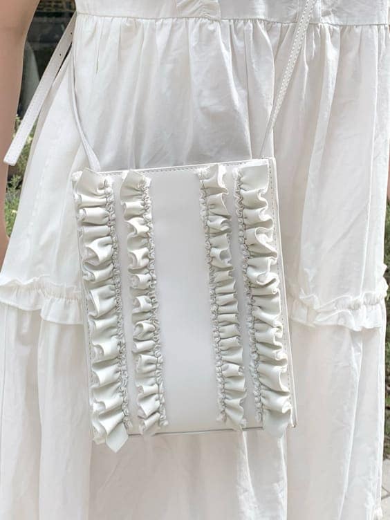 ホワイト系のワンピース、ピンク系のサンダル、ホワイト系のショルダーバッグを着用したレディースの春コーディネートの6枚目の写真