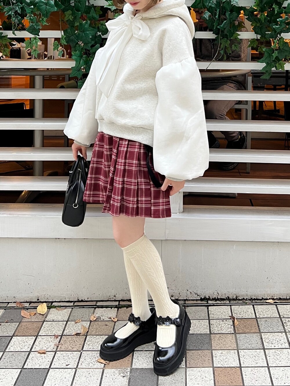 ブラック系のローファー、ホワイト系のパーカー、ブラック系のボストンバッグを着用したレディースの冬コーディネートの2枚目の写真