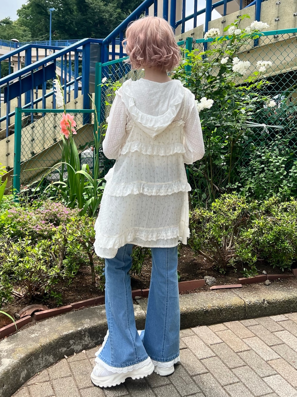 ホワイト系のチュニック、ホワイト系のTシャツ/カットソー、ブルー系のデニムパンツを着用したレディースの夏コーディネートの6枚目の写真