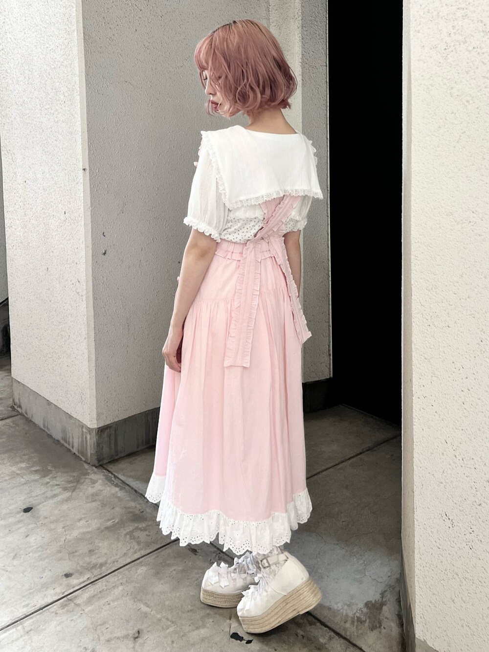 ホワイト系のTシャツ/カットソー、ピンク系のジャンパースカート、ホワイト系のサンダルを着用したレディースの夏コーディネートの7枚目の写真