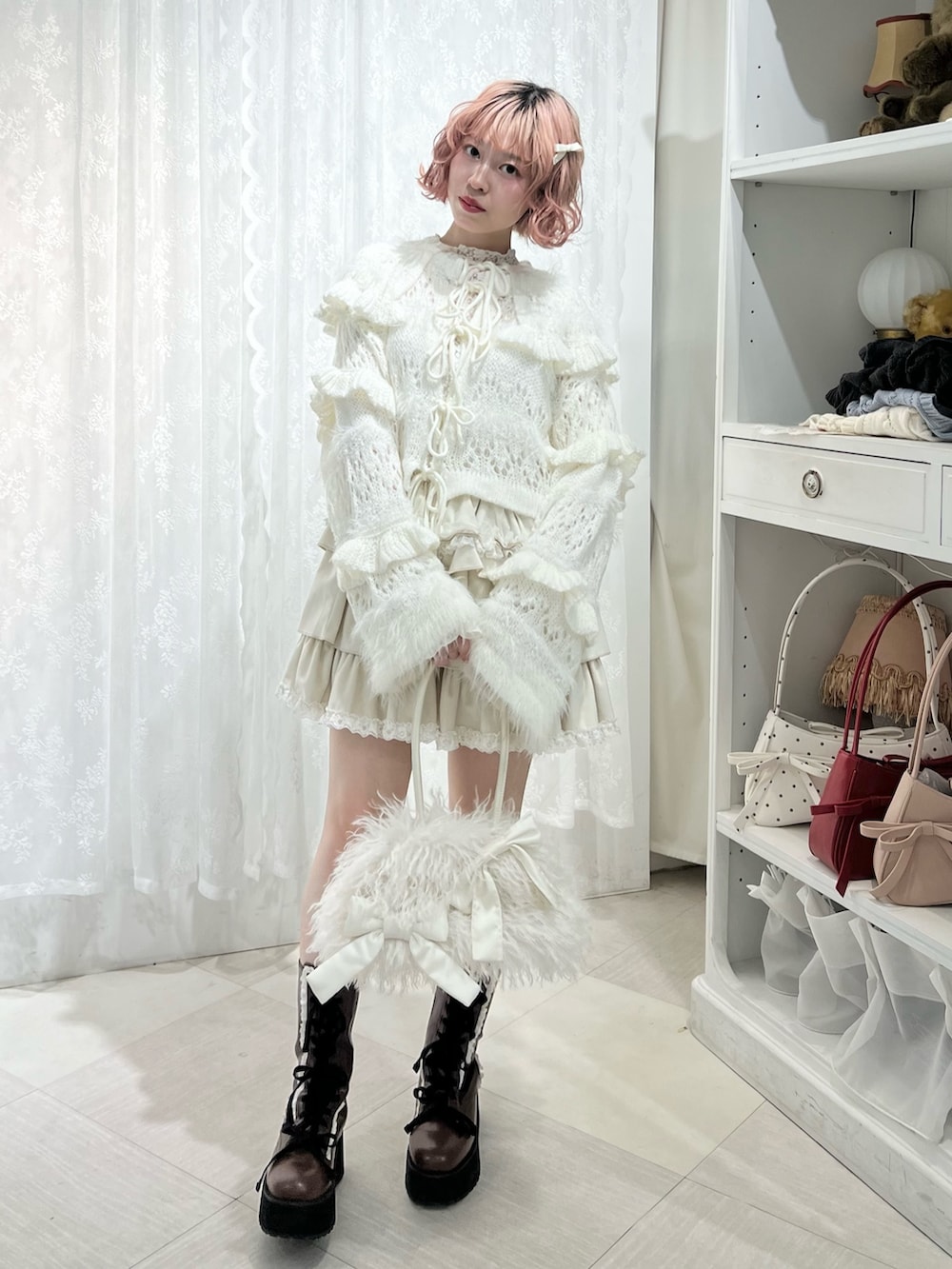 ホワイト系のボストンバッグ、ブラウン系のブーツ、ホワイト系のスカートを着用したレディースの夏コーディネートの3枚目の写真