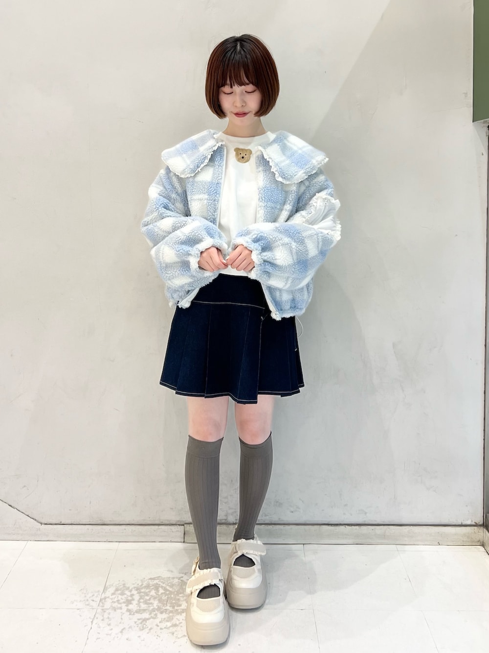 ブルー系のデニムスカート、ブルー系のブルゾン、ホワイト系のスウェットを着用したレディースの冬コーディネートの4枚目の写真