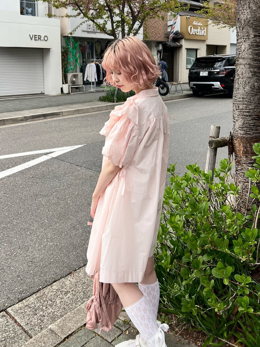 ピンク系のワンピース、ピンク系のトートバッグ、ホワイト系のスニーカーを着用したレディースの春コーディネートの7枚目の写真