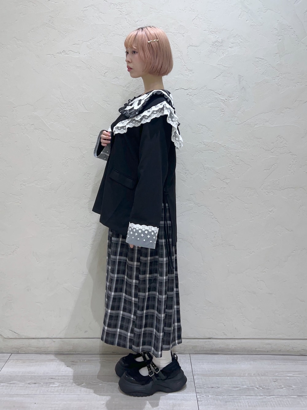 ブラック系のテーラードジャケット、ホワイト系のハンドバッグ、ブラック系のスニーカーを着用したレディースの秋コーディネートの2枚目の写真