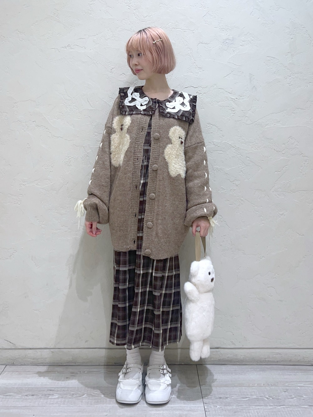 ホワイト系のハンドバッグ、ブラウン系のカーディガン/ボレロ、ブラウン系のワンピースを着用したレディースの秋コーディネートの9枚目の写真