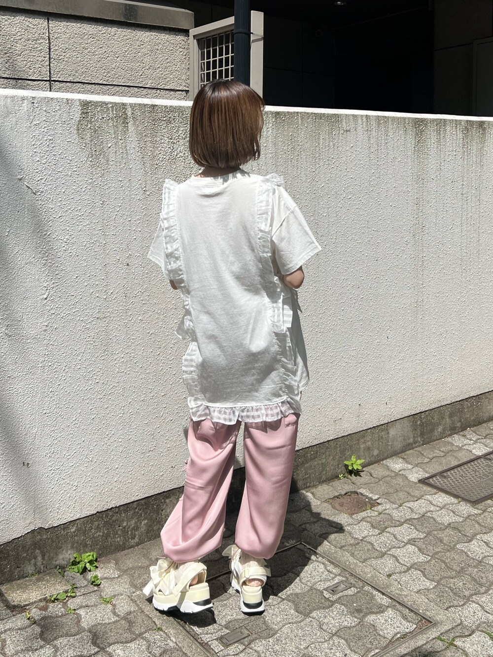 ピンク系のカーゴパンツ、ホワイト系のTシャツ/カットソー、ホワイト系のサンダルを着用したレディースの春コーディネートの3枚目の写真