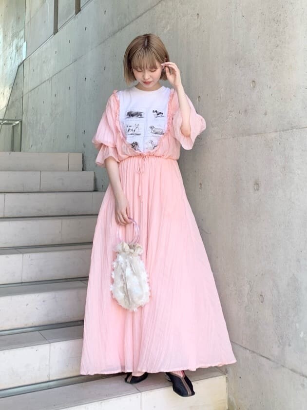 ブラック系のパンプス、ホワイト系のハンドバッグ、ピンク系のワンピースを着用したレディースの春コーディネートの3枚目の写真