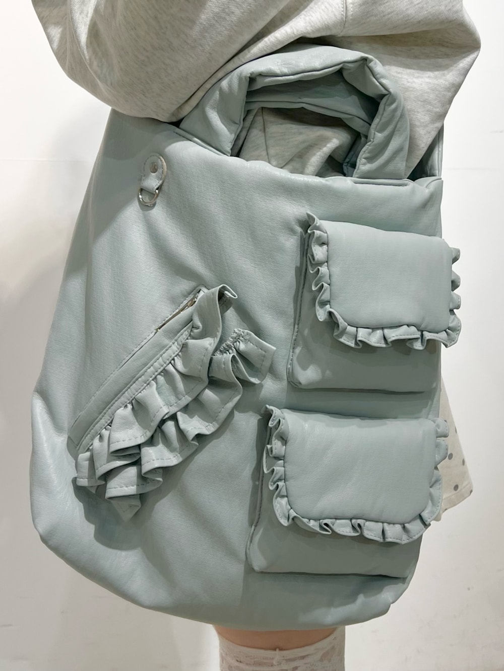 グレー系のパーカー、ホワイト系のスカート、ブルー系のショルダーバッグを着用したレディースの秋コーディネートの9枚目の写真