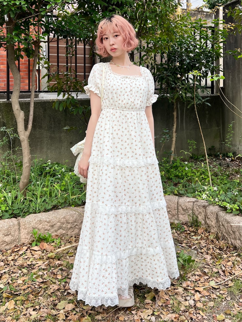 ホワイト系のワンピース、ホワイト系のショルダーバッグ、ベージュ系のサンダルを着用したレディースの春コーディネートの2枚目の写真