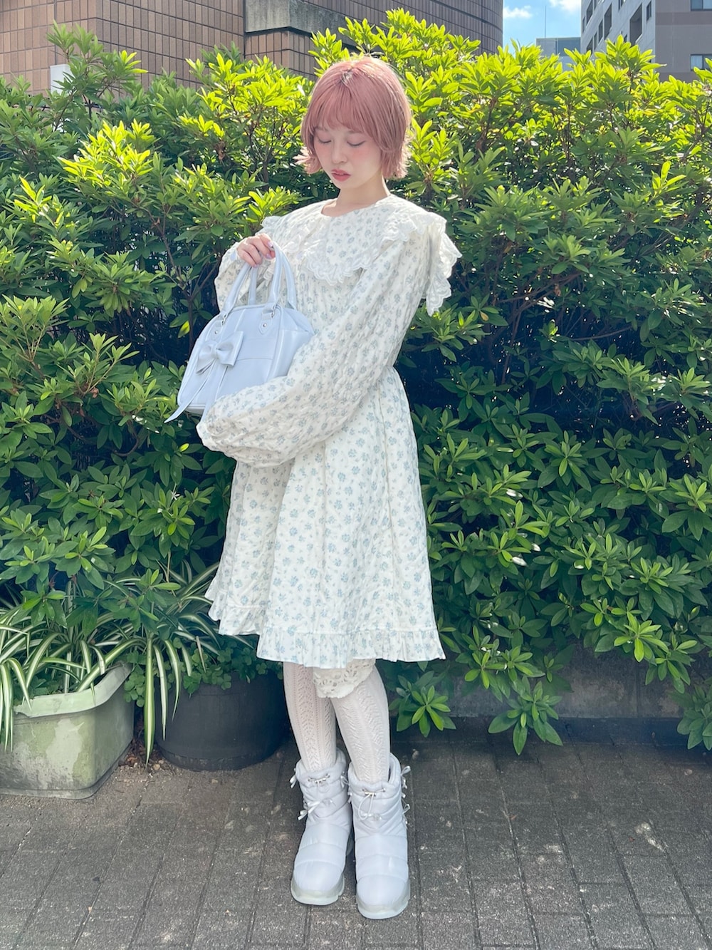 ホワイト系のワンピース、ブルー系のハンドバッグ、ブルー系のブーツを着用したレディースの夏コーディネートの4枚目の写真