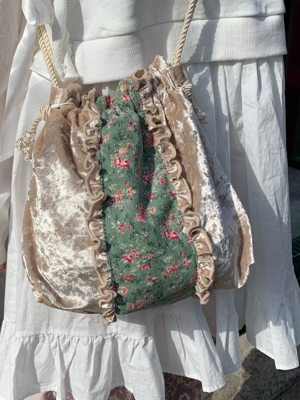 ホワイト系のハンドバッグ、パープル系のその他パンツ、ホワイト系のワンピースを着用したレディースの冬コーディネートの6枚目の写真