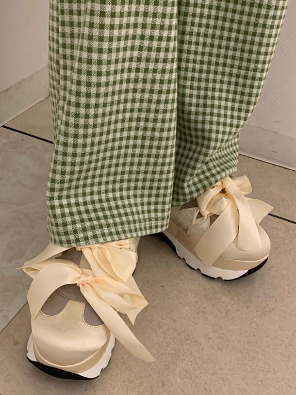 グリーン系のその他パンツ、ホワイト系のスニーカー、ホワイト系のハンドバッグを着用したレディースの夏コーディネートの6枚目の写真