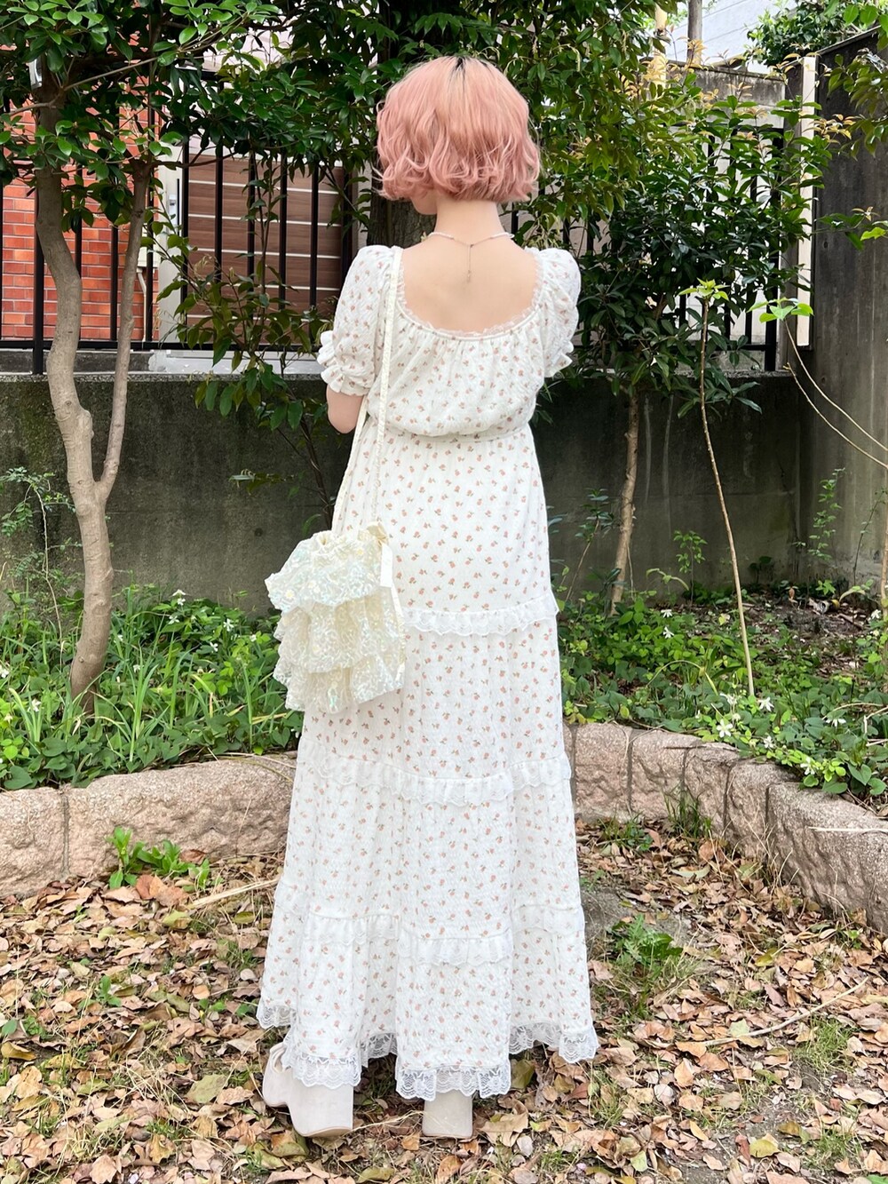 ホワイト系のワンピース、ホワイト系のショルダーバッグ、ベージュ系のサンダルを着用したレディースの春コーディネートの5枚目の写真