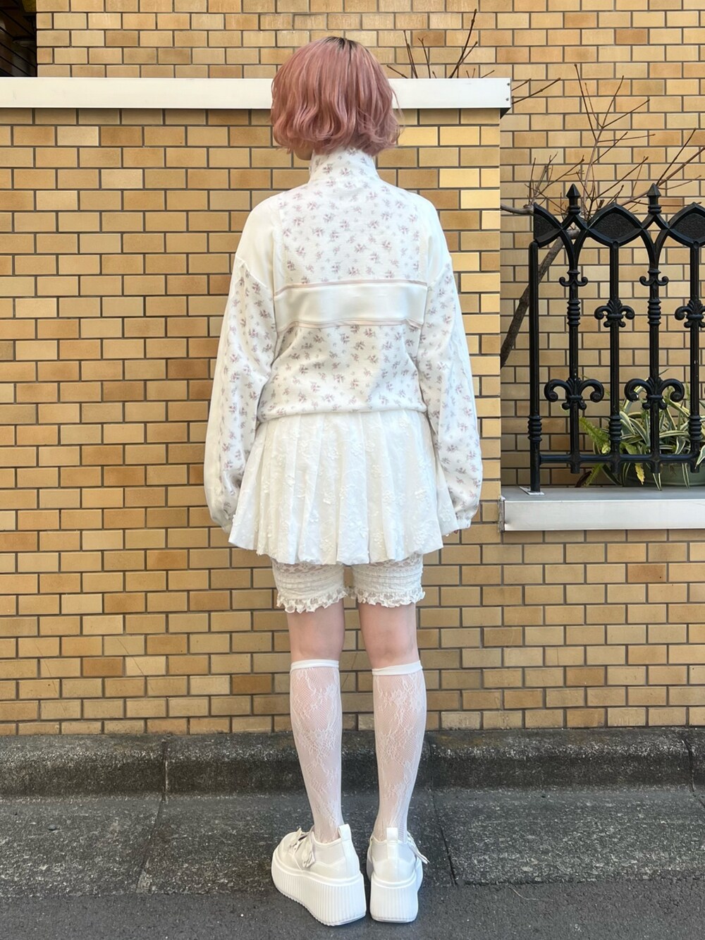 ピンク系のジャージ、ホワイト系のスカート、ホワイト系のスニーカーを着用したレディースの冬コーディネートの5枚目の写真