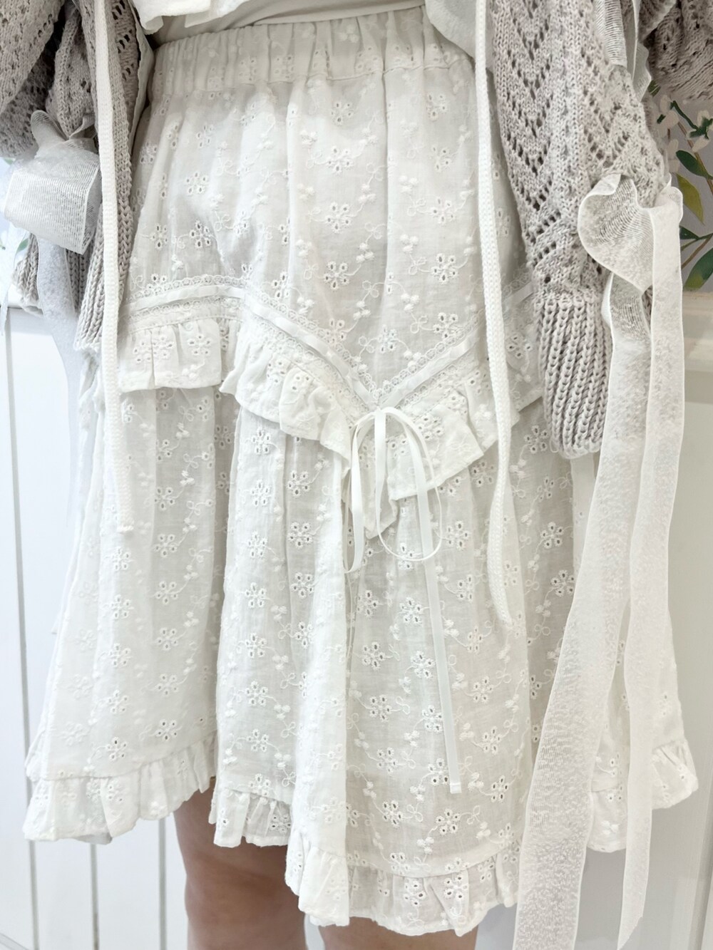 グレー系のカーディガン/ボレロ、ホワイト系のシャツ/ブラウス、ホワイト系のスカートを着用したレディースの冬コーディネートの10枚目の写真