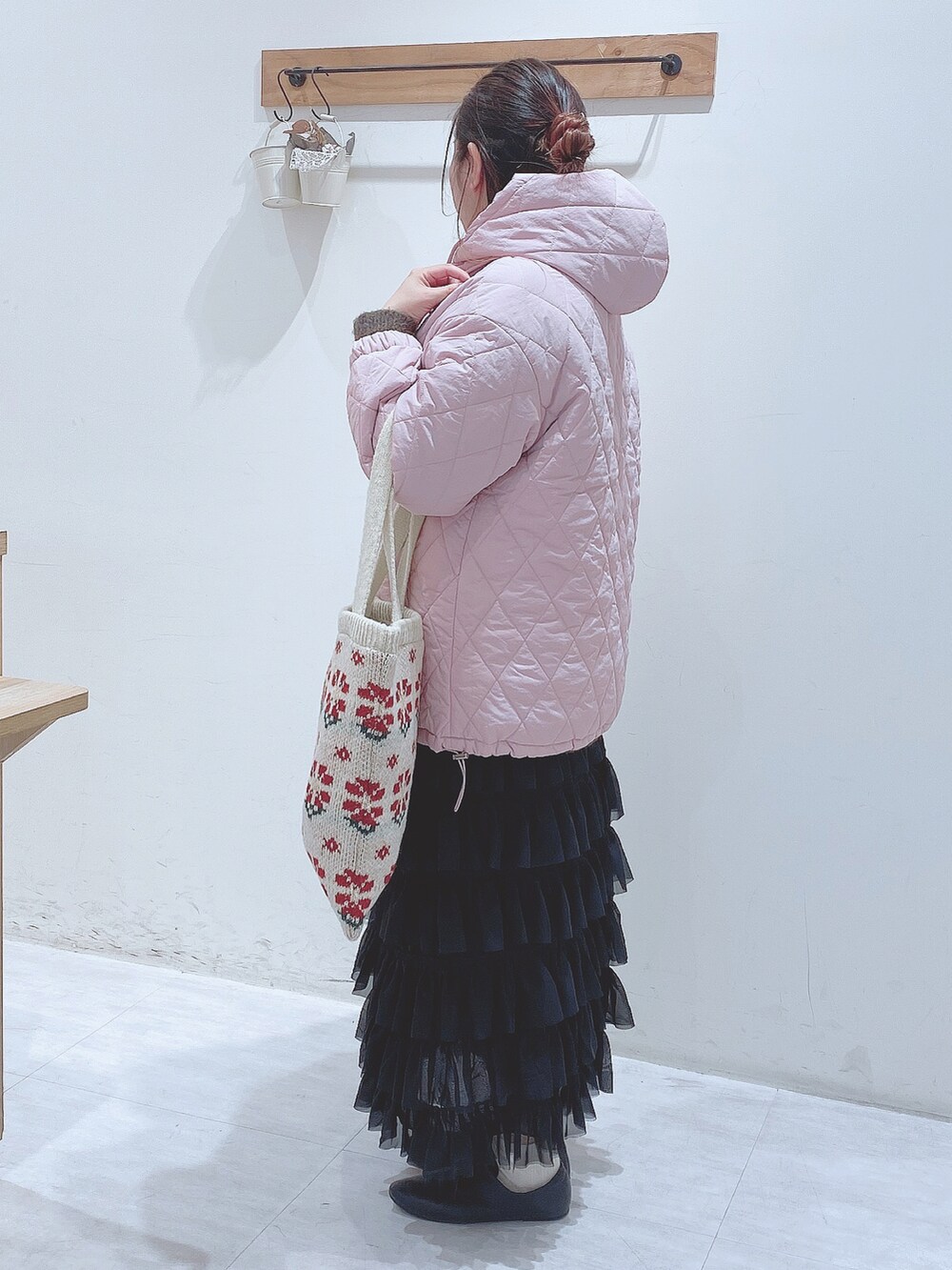 ブラック系のスカート、グリーン系のニット/セーター、ピンク系のノーカラージャケットを着用したレディースの冬コーディネートの4枚目の写真