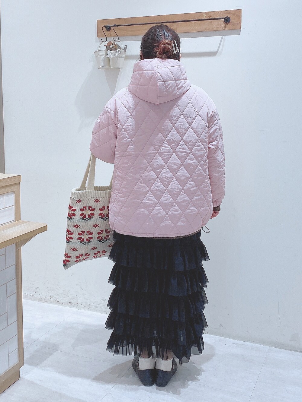 ブラック系のスカート、グリーン系のニット/セーター、ピンク系のノーカラージャケットを着用したレディースの冬コーディネートの5枚目の写真