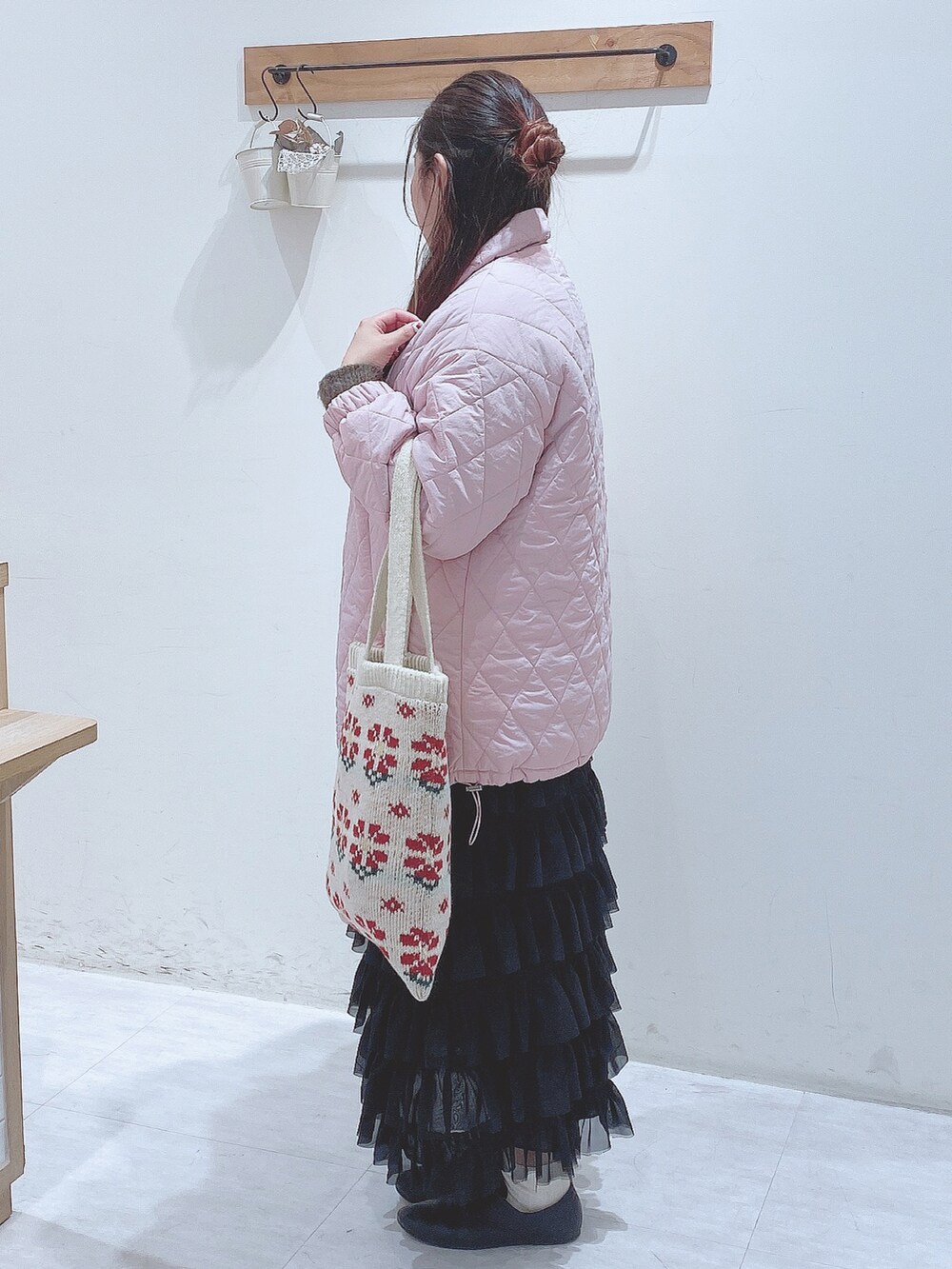 ブラック系のスカート、グリーン系のニット/セーター、ピンク系のノーカラージャケットを着用したレディースの冬コーディネートの2枚目の写真