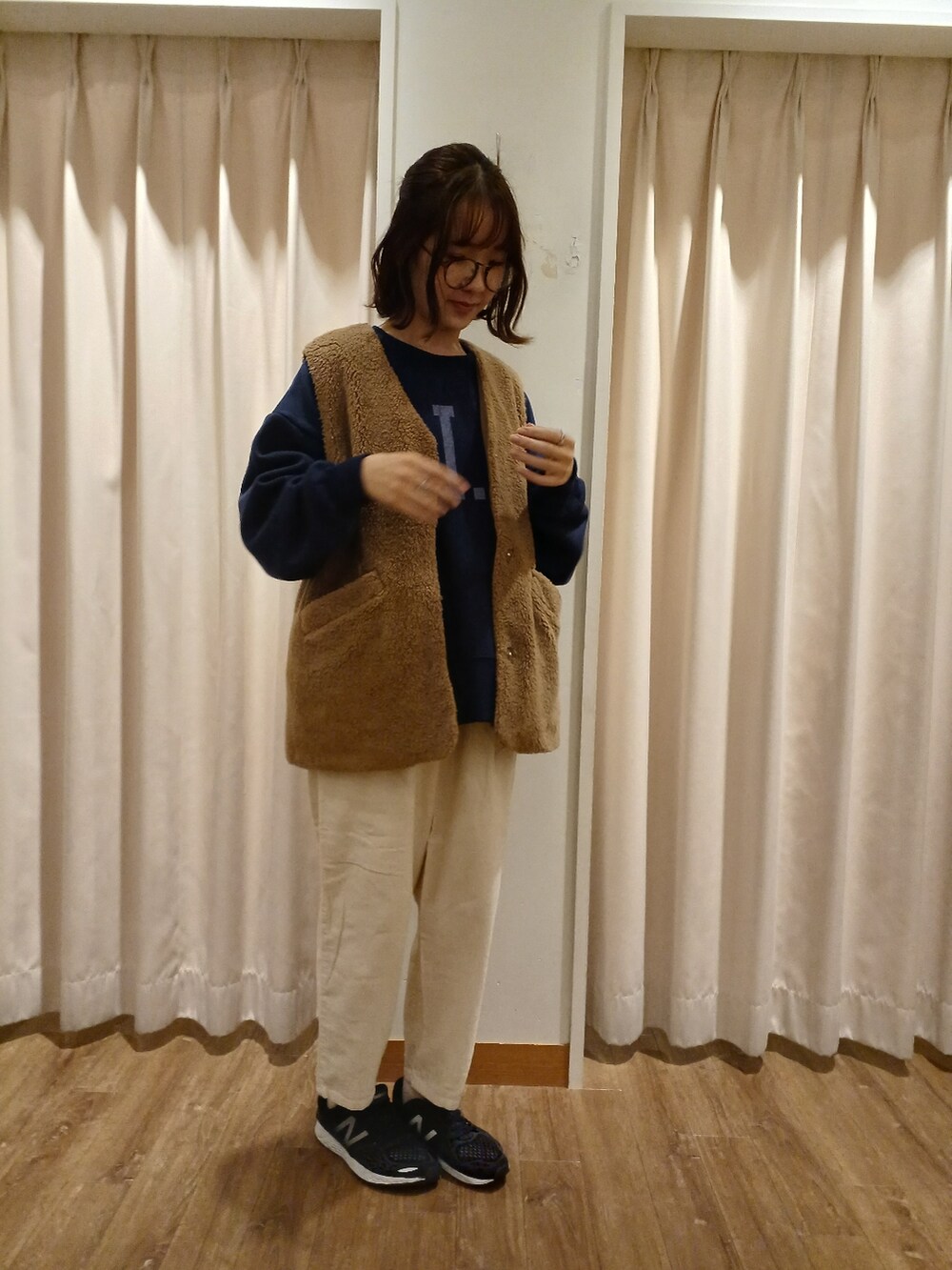 ブラウン系のベスト、ブルー系のTシャツ/カットソー、ホワイト系のその他パンツを着用したレディースの秋コーディネートの2枚目の写真