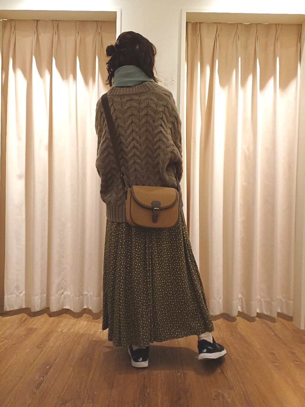 ブラウン系のカーディガン/ボレロ、ブラウン系のショルダーバッグ、グリーン系のスカートを着用したレディースの秋コーディネートの2枚目の写真